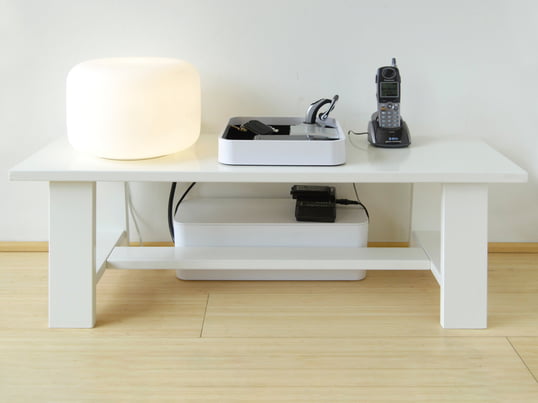 Le CableBox de Bluelounge en vue d'ambiance : La boîte de rangement fait disparaître rapidement et facilement l'enchevêtrement de câbles sous la table basse.